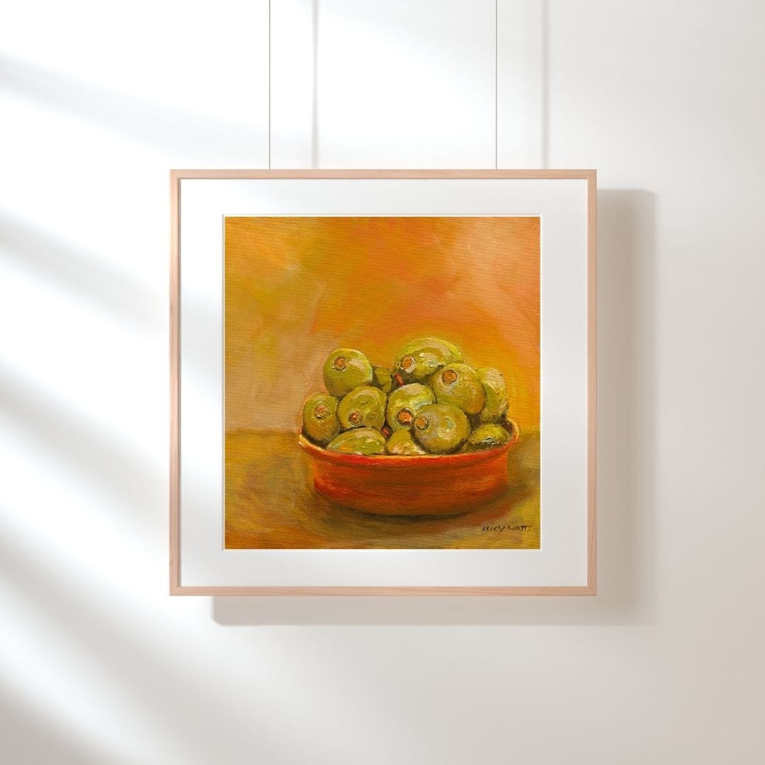 Framed painting of a bowl of green apples on an orange background