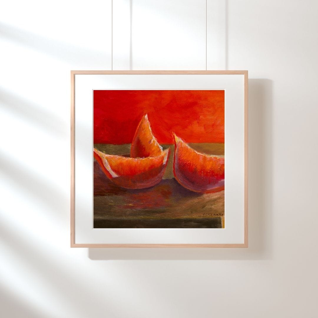 Framed artwork of two red abstract shapes on a white wall