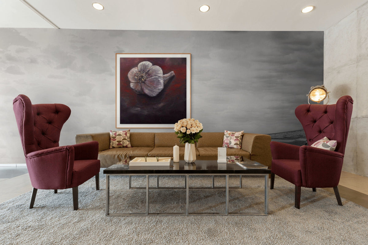 Living room with two red armchairs, a coffee table, and a painting on the wall.