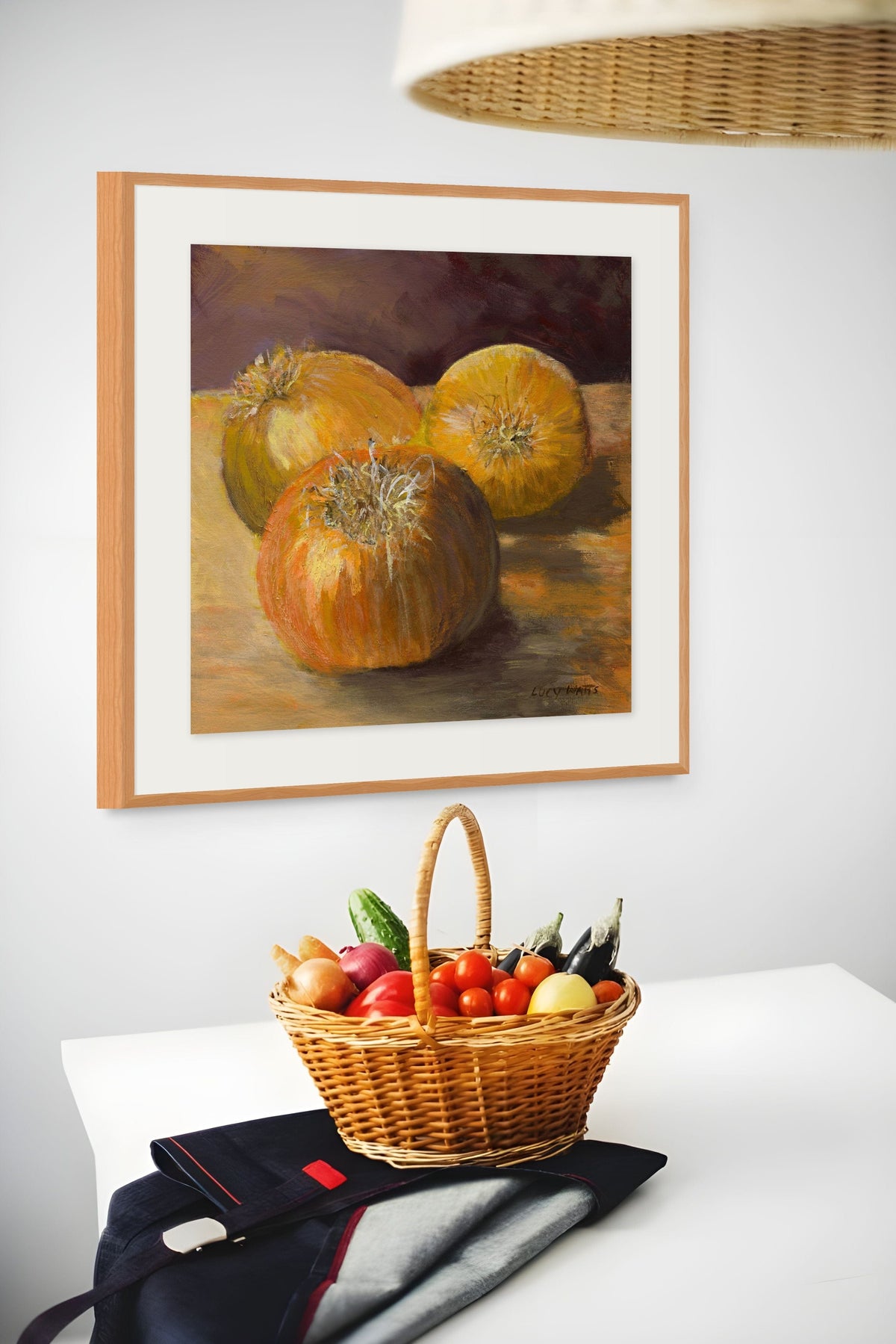 Framed still life painting of pumpkins above a basket of fruits and vegetables on a table.